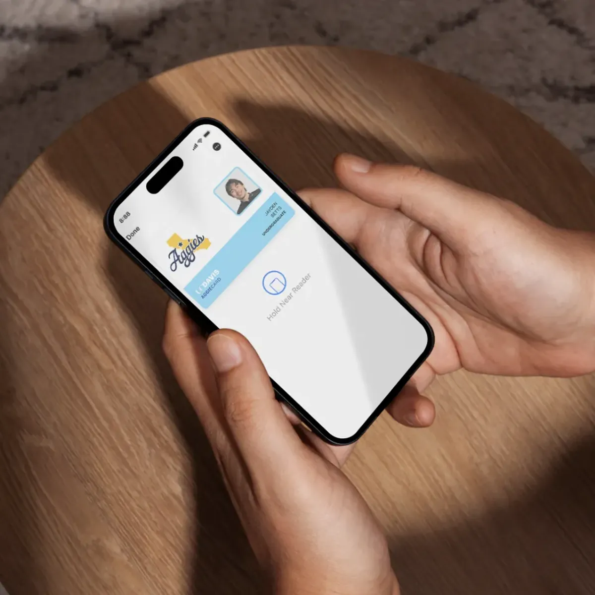 The redesigned UC Davis Member ID open in Apple Wallet on a phone held in hand