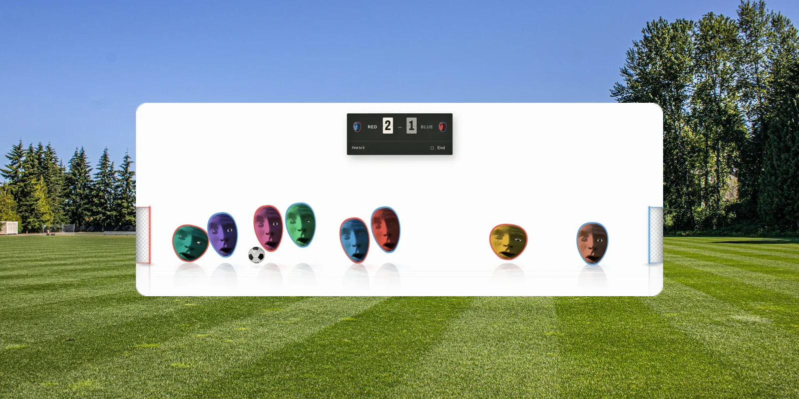 Cut-out heads strung out across a pitch with the ball loose between them and a scoreboard above.